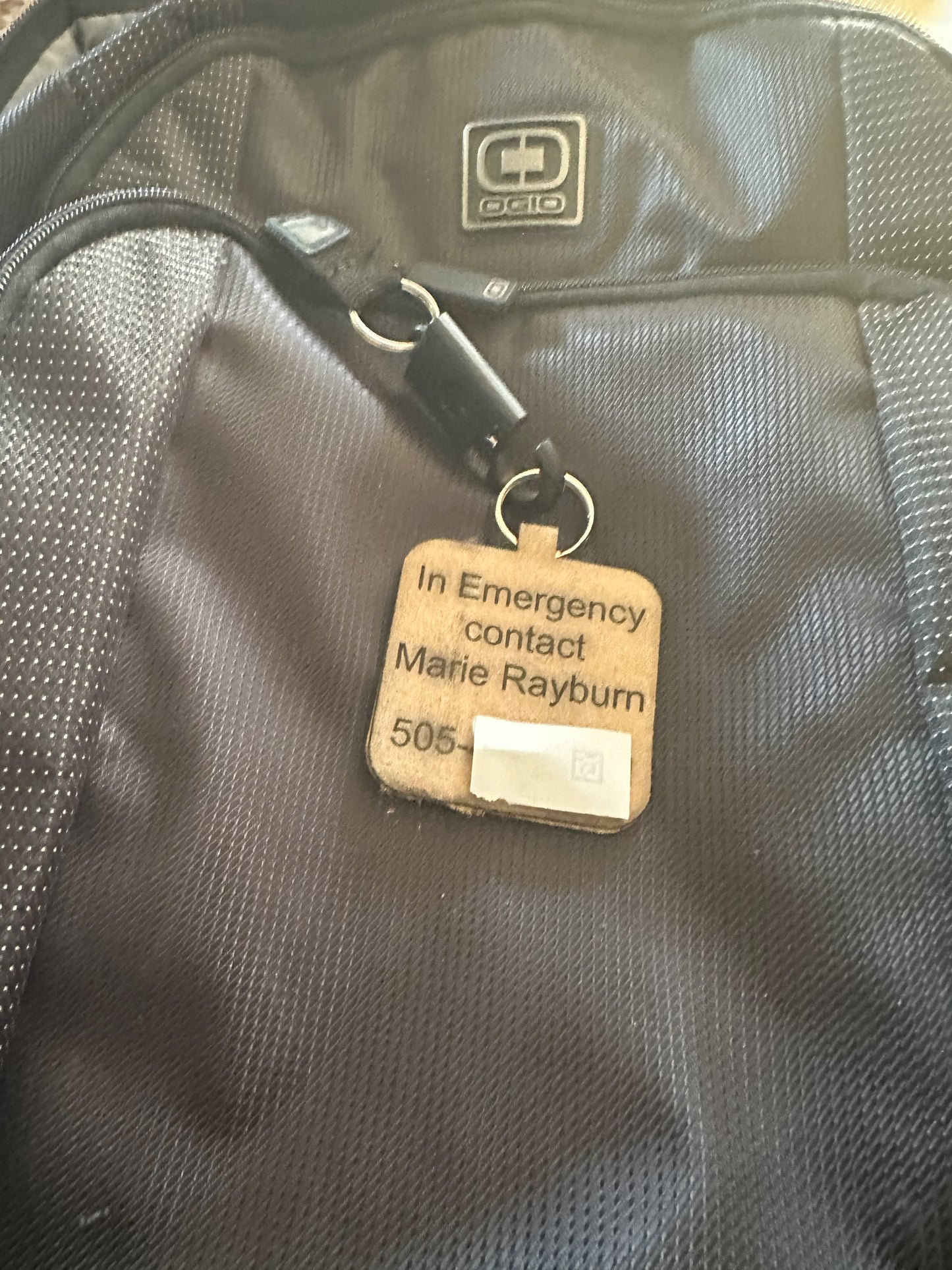 custom personalized engraved leather backpack tag emergency contact information closeup wide angle