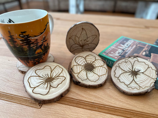 Wood cut coasters with flowers laser engraved on them.
